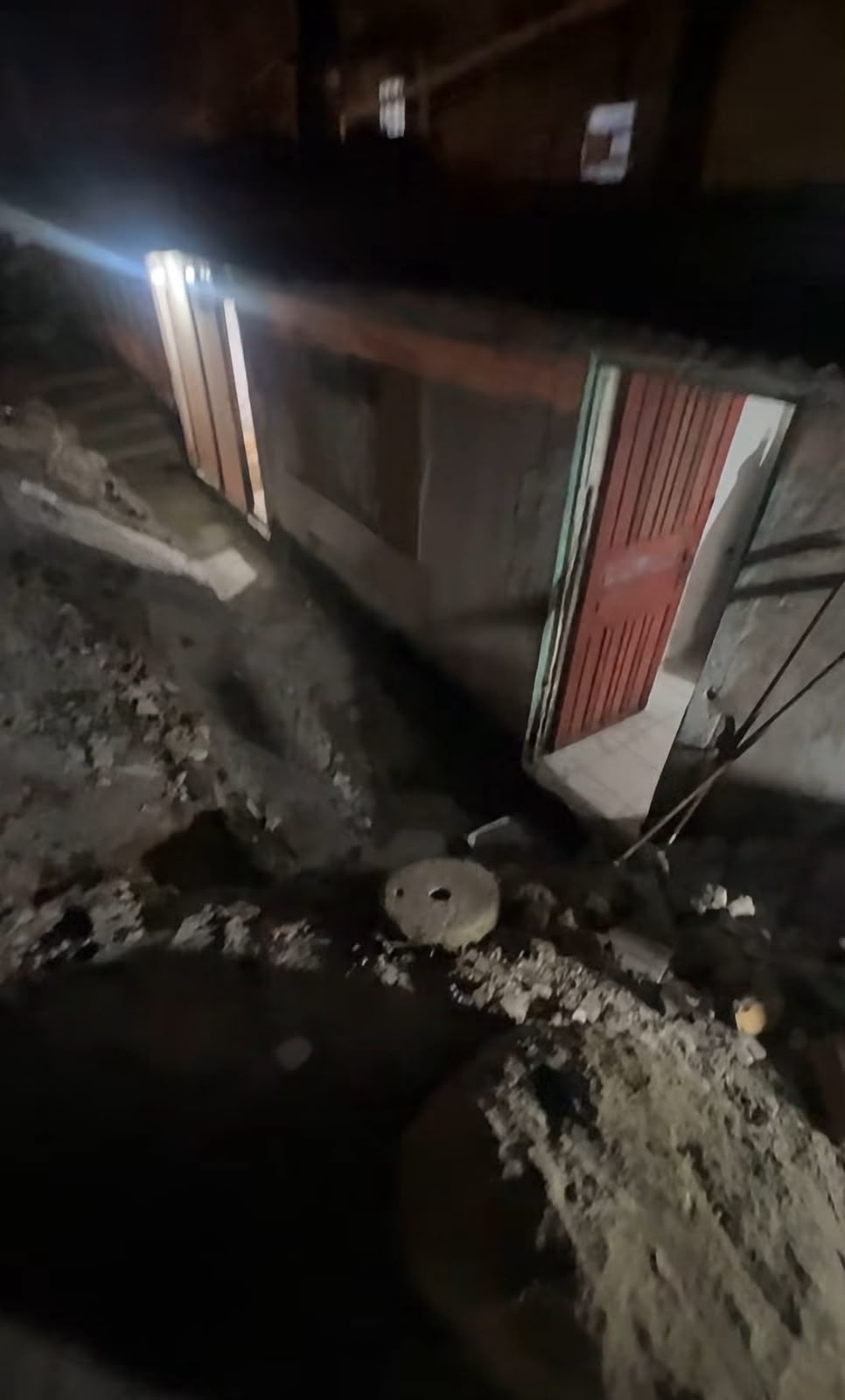 Entrada da casa cercada por escombros