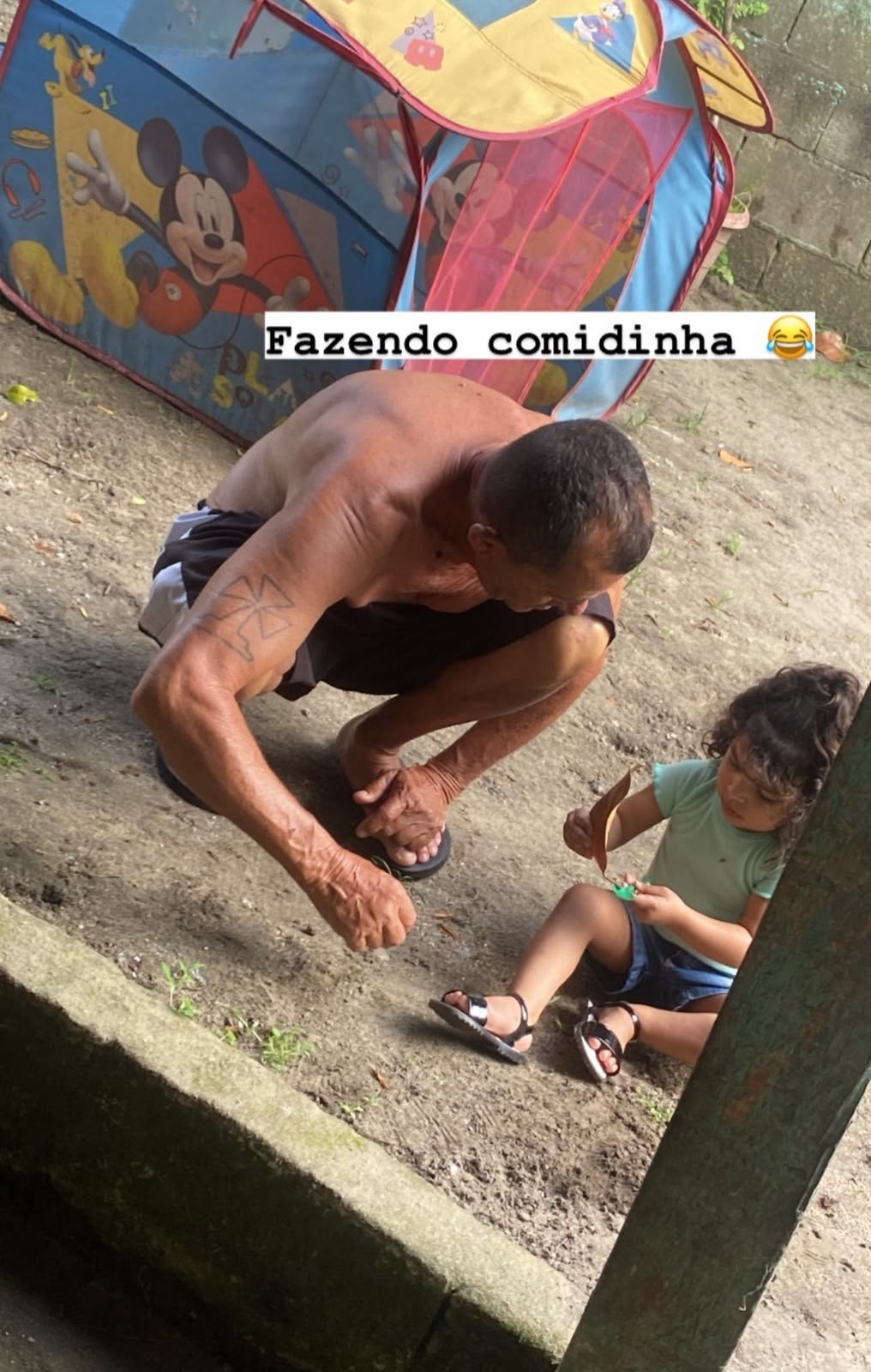 Pai da Helen brincando com o neto no quintal